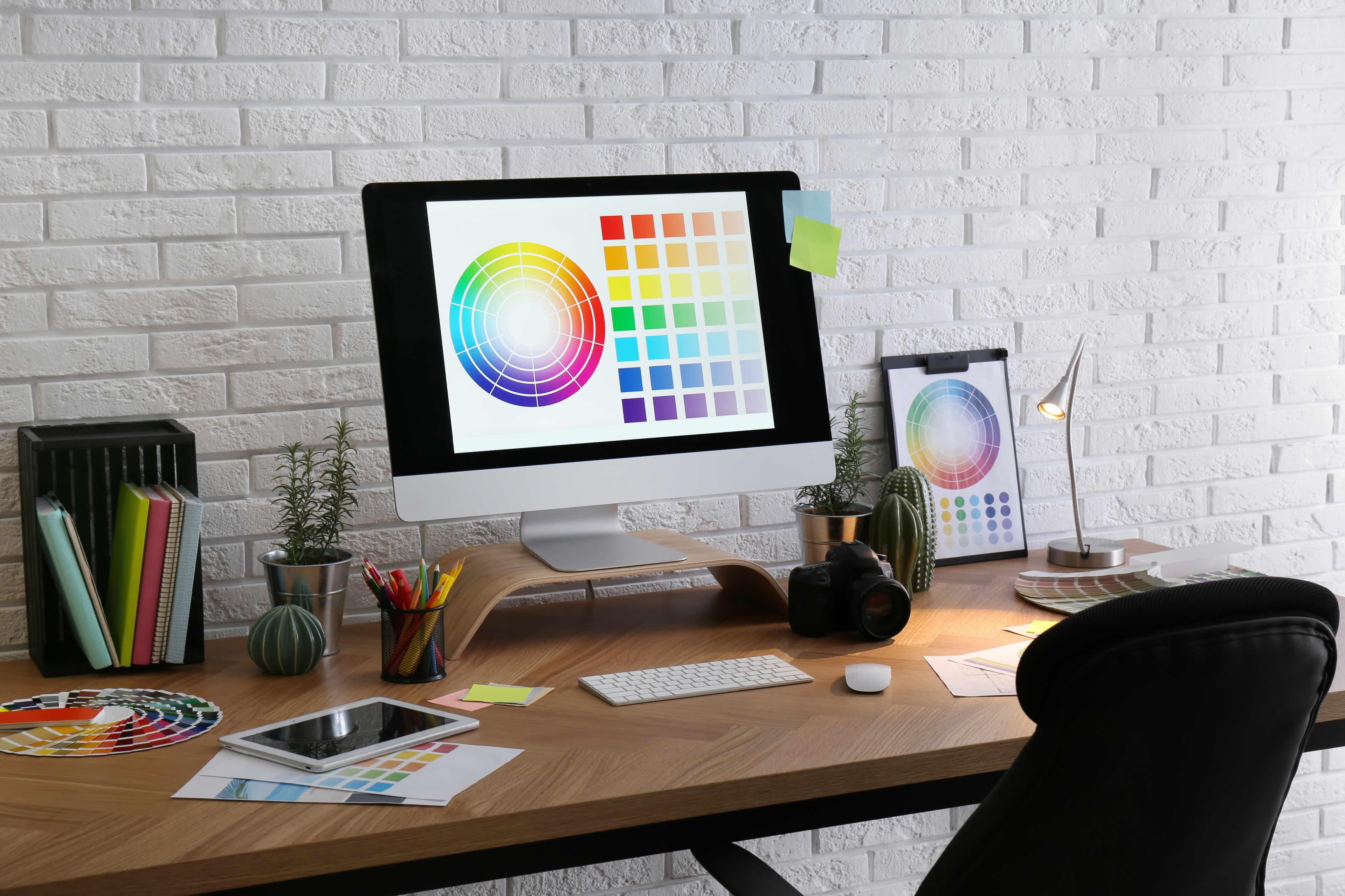 Designer reviewing layout options on screen while sketching the underlying grid