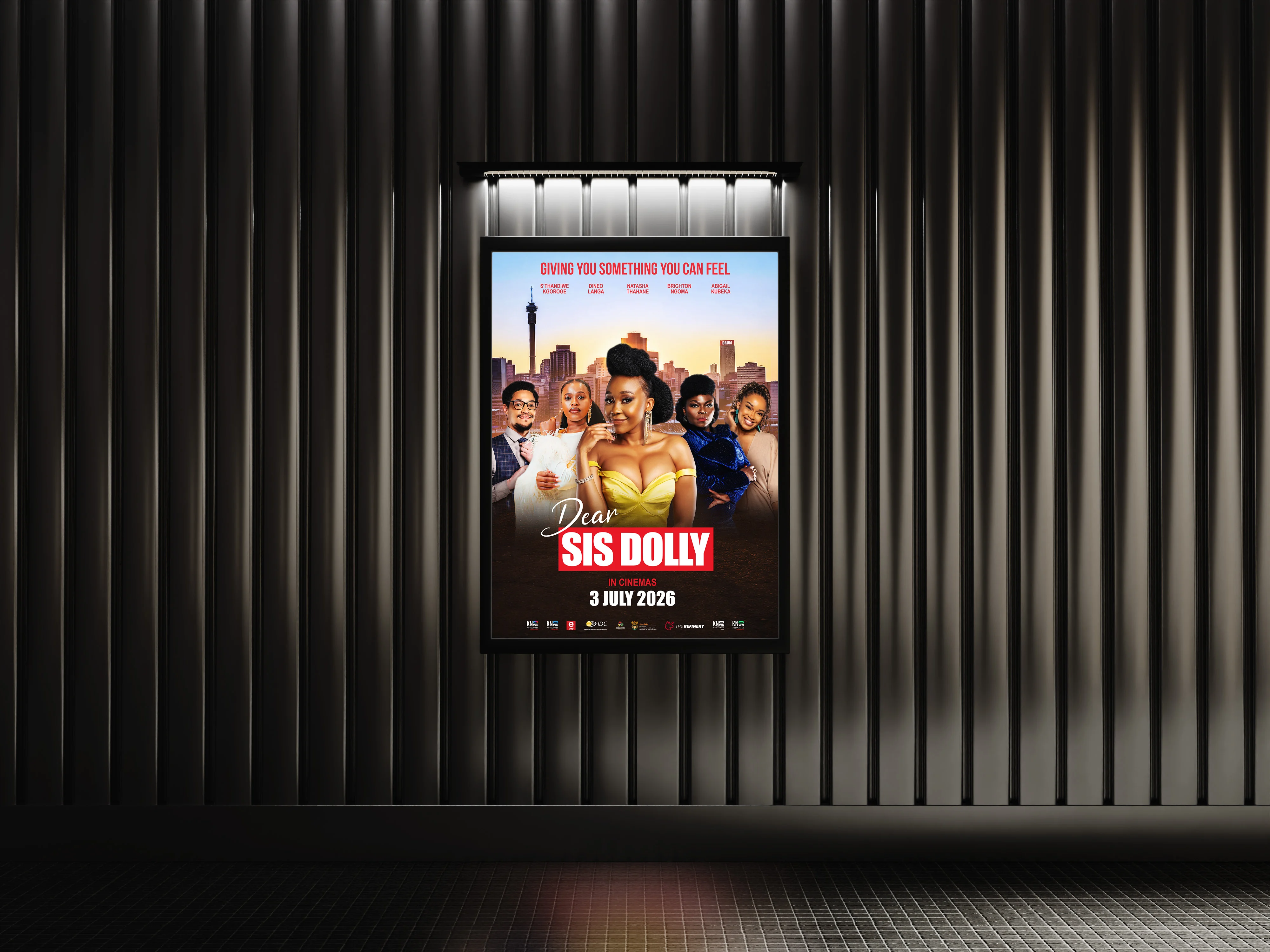 Framed Dear Sis Dolly poster presented in a lit cinema foyer display against a dark ribbed wall.