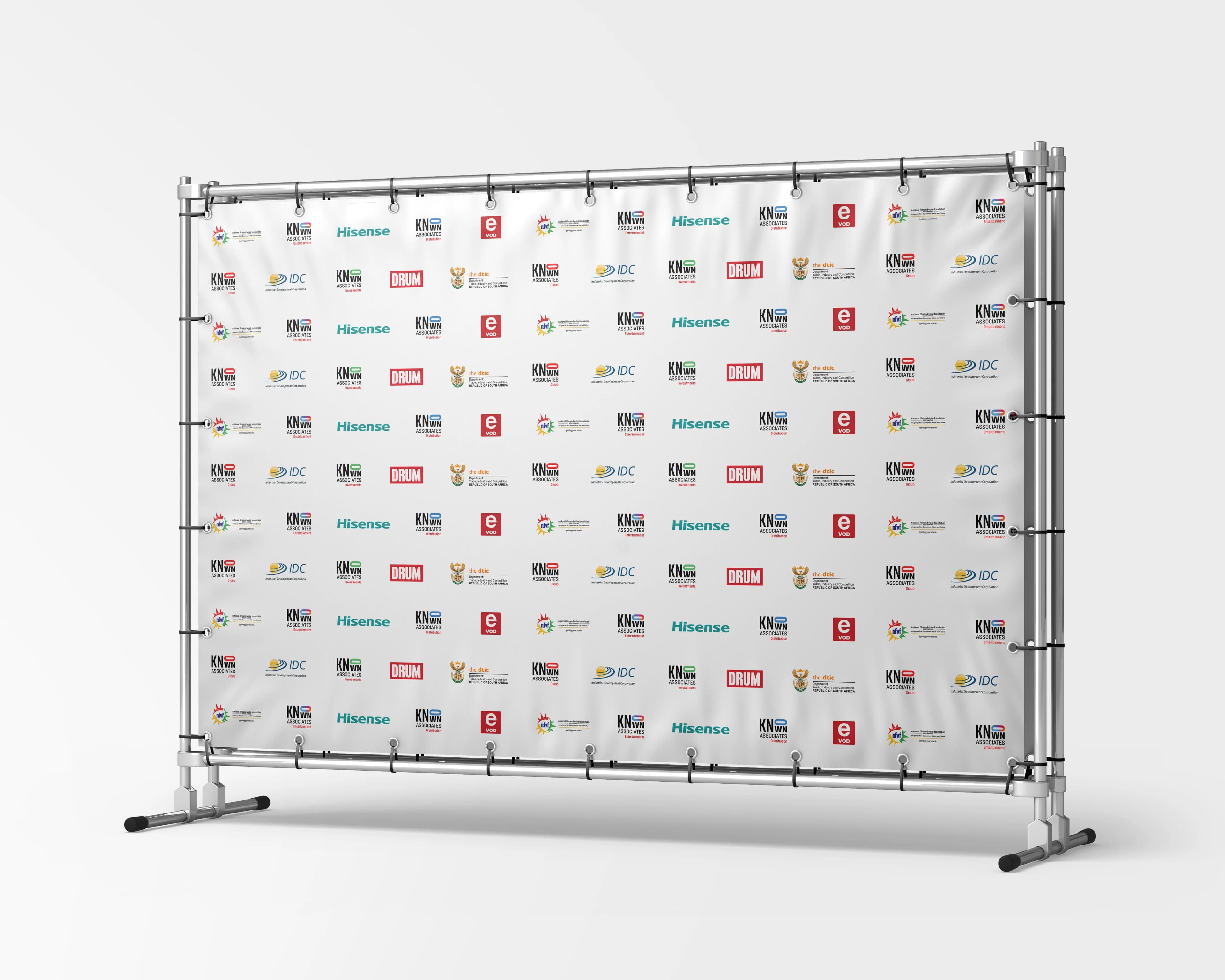 Dear Sis Dolly press wall presented on a portable frame, tiled with the production partner and sponsor logos on a white banner.