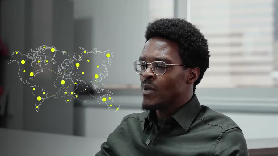A world map rendered as a network of pale connecting lines with yellow nodes pulsing across it, overlaid beside a speaker in profile.